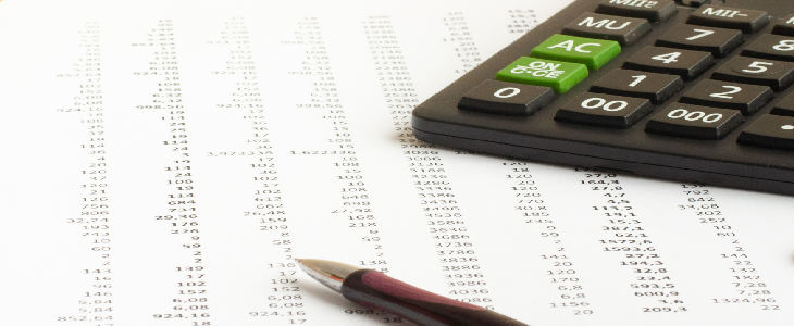 Calculator, pen, and sheet of paper to represent tax reconciliation